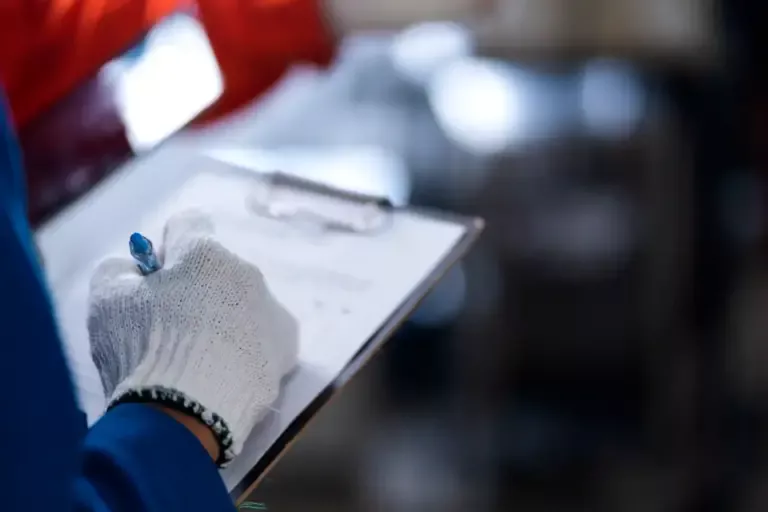 Denetimlerin Kilit Noktası: İSG Onaylı Defter Nasıl Tutulur, Hatalardan Nasıl Kaçınılır? 1 Bir noterin, İSG Tespit ve Öneri Defteri'nin sayfalarını resmi bir mühürle onaylarkenki yakın çekim görüntüsü.