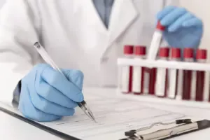İşyeri hekimi, periyodik sağlık taraması sonuçlarına göre çalışanların kan tahlili raporunu inceliyor.